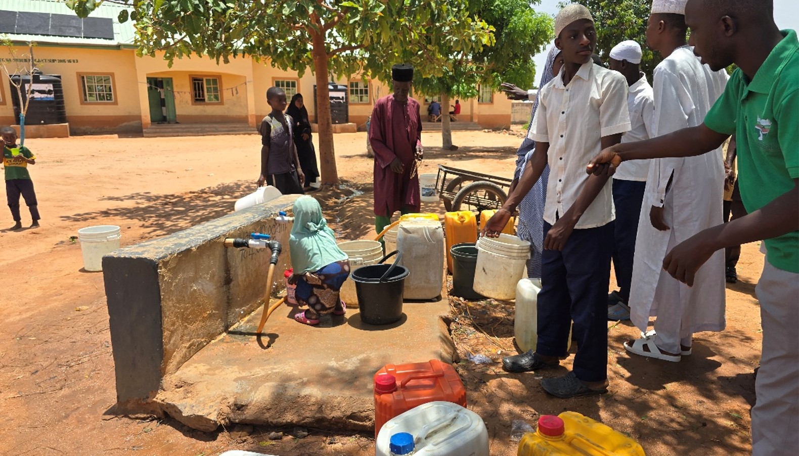 Students and community members collecting water at the newly completed solar-powered borehole, now running 24 hours a day.